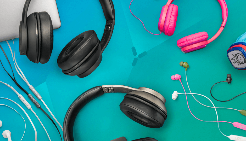 Olika hörlurar och in-ear-hörlurar från märket ISY, laptop från PEAQ, olika färger, mot grön-blå bakgrund